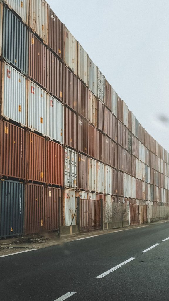 The Art of Drawing Readers In: Your attractive post title goes here High-rise stack of shipping containers along an industrial road in foggy weather.